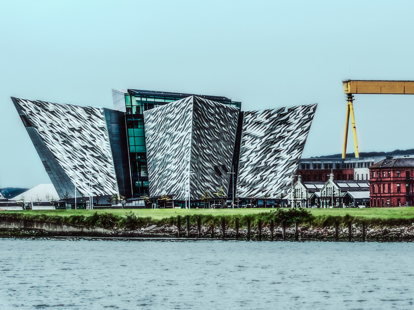 The Titanic Belfast building beside the water, with the yellow shipyard crane behind it