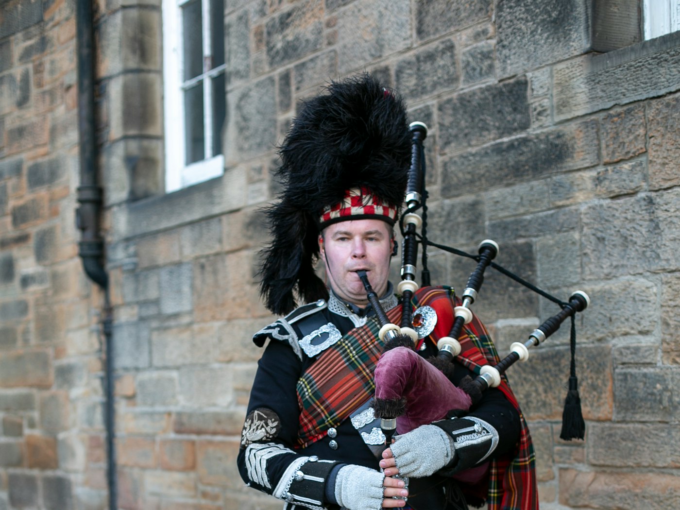 A piper in full Highland dress playing the bagpipes